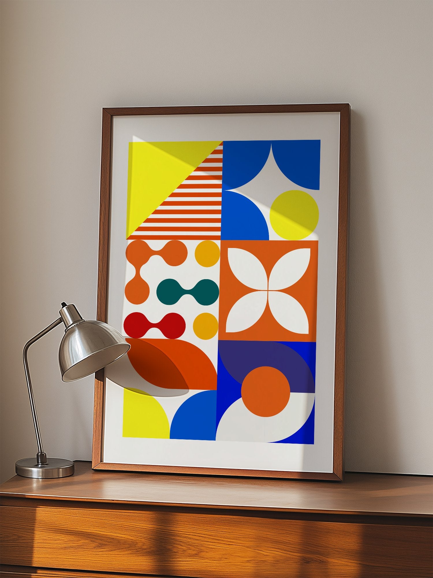Geometric abstract wall art with bold blue curves, orange circles, yellow, displayed in modern living room setting