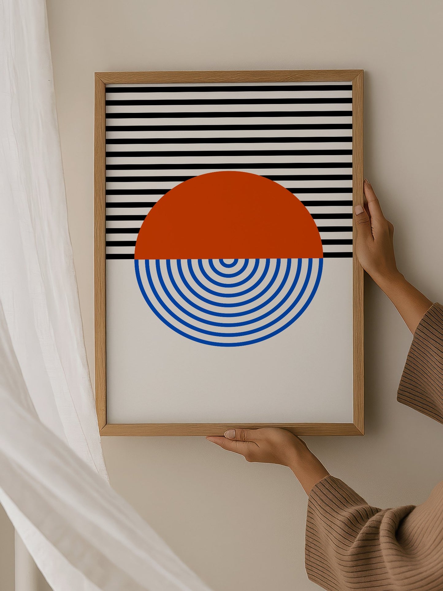 Geometric abstract wall art featuring split circle with orange top and blue, hanging in contemporary bedroom interior