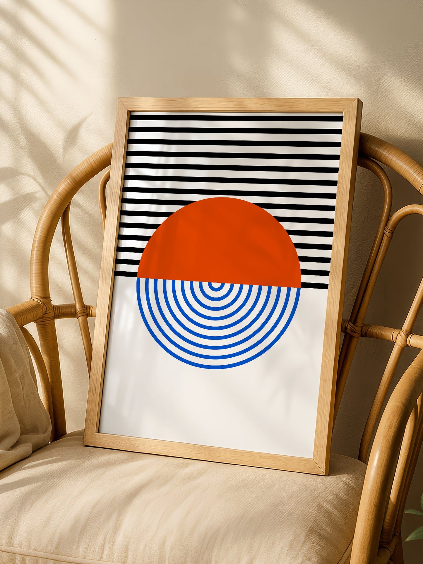 Geometric abstract wall art featuring split circle with orange top and blue, shown in minimalist home office space