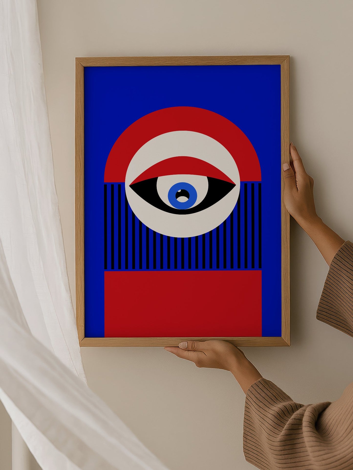 Abstract geometric portrait art with bold central eye motif in cobalt blue, hanging in contemporary bedroom interior