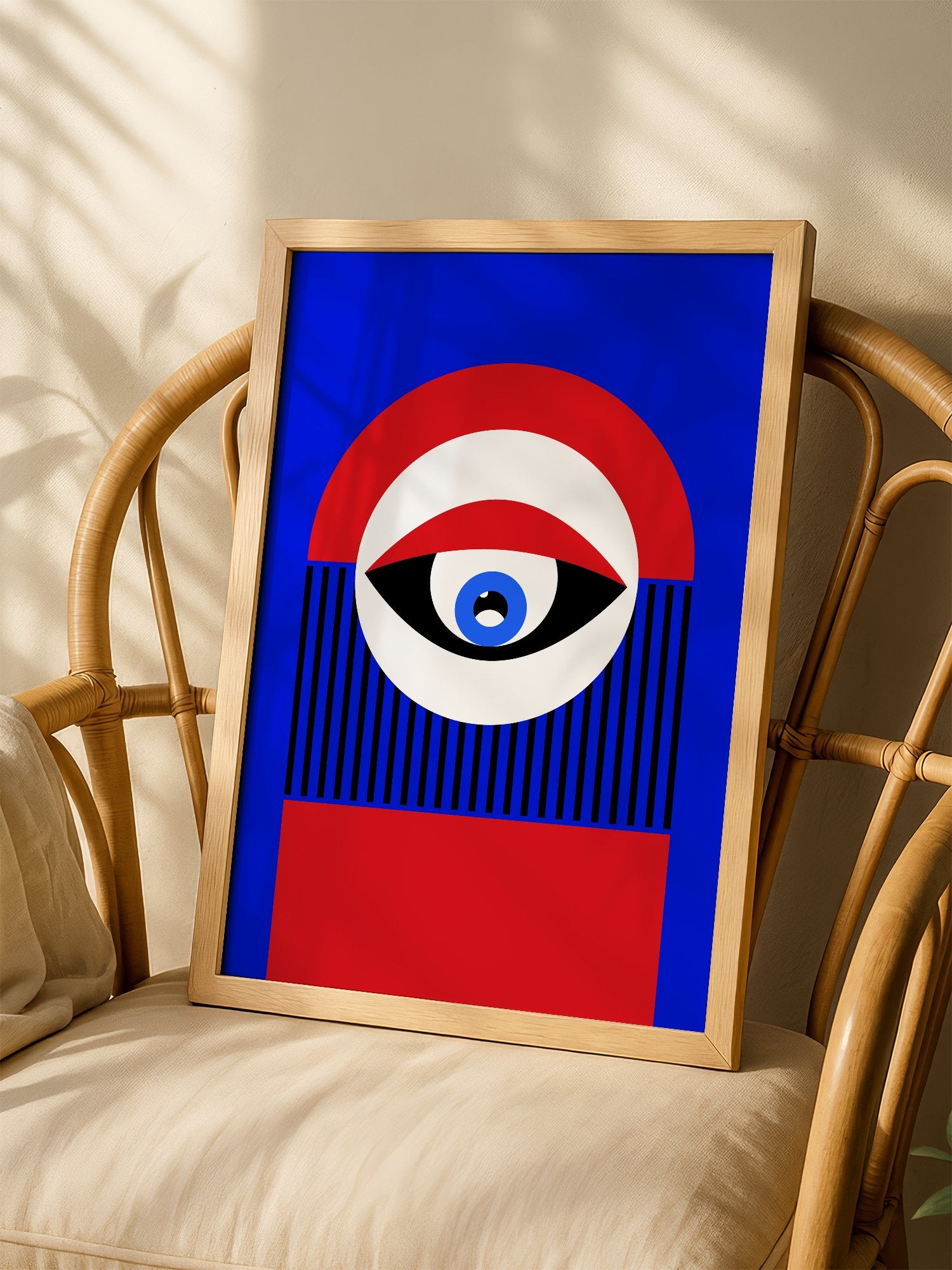 Abstract geometric portrait art with bold central eye motif in cobalt blue, shown in minimalist home office space