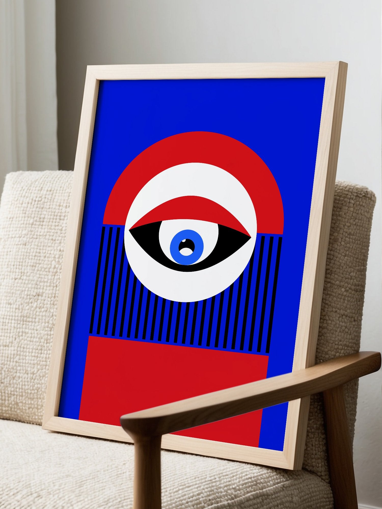 Abstract geometric portrait art with bold central eye motif in cobalt blue, displayed in modern living room setting