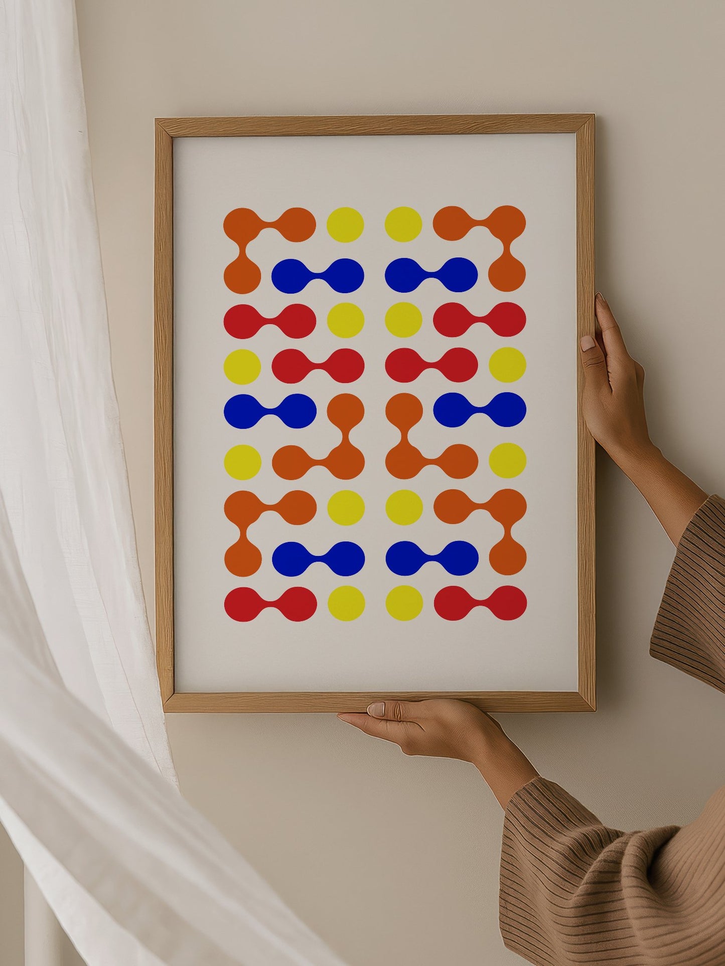 Mid-century modern geometric print with colourful molecular shapes in orange, hanging in contemporary bedroom interior