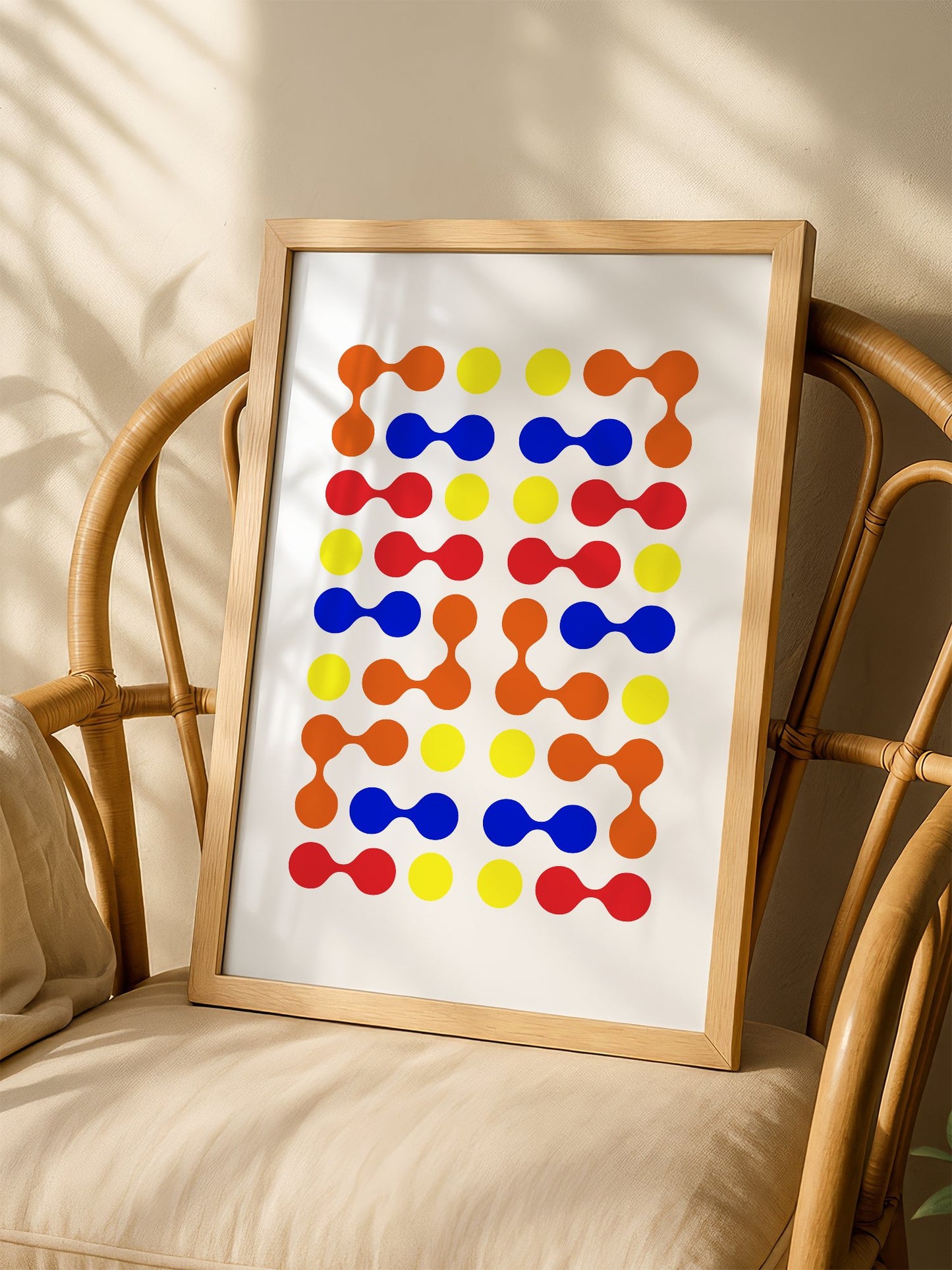 Mid-century modern geometric print with colourful molecular shapes in orange, shown in minimalist home office space