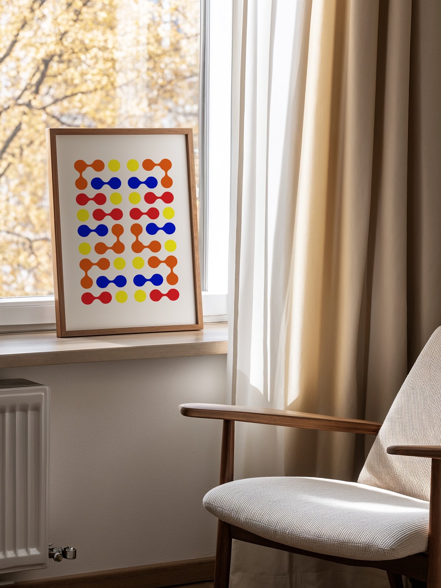 Mid-century modern geometric print with colourful molecular shapes in orange, mounted in bright gallery wall arrangement