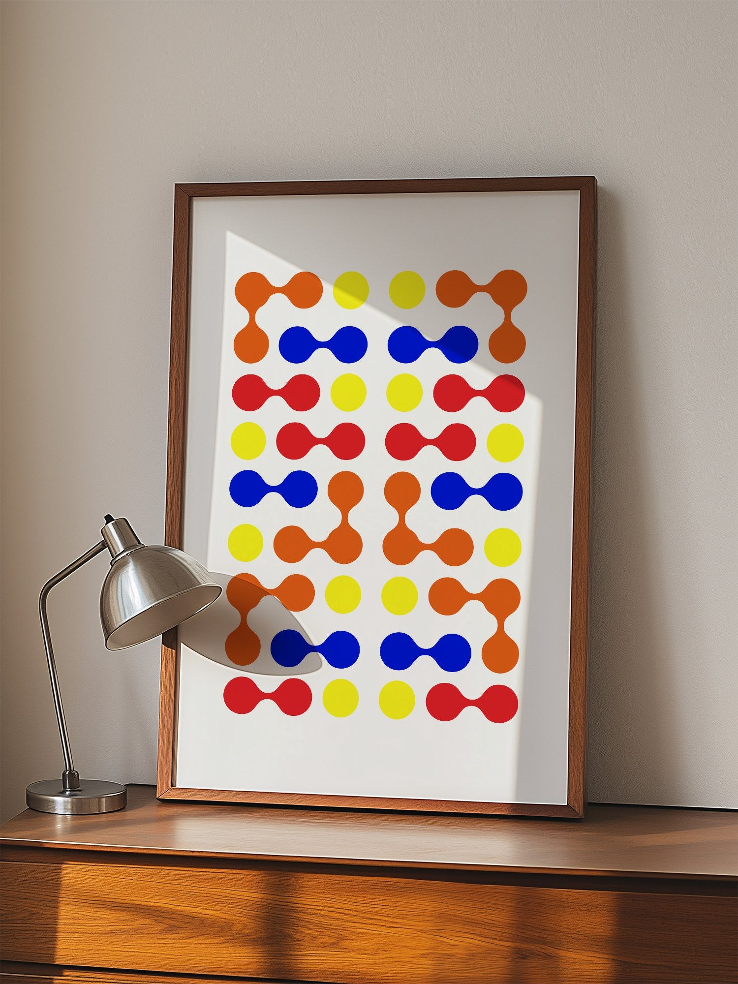 Mid-century modern geometric print with colourful molecular shapes in orange, displayed in modern living room setting
