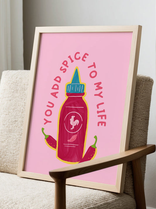 Playful pink spice bottle wall art print featuring rooster logo and chili, displayed in modern living room setting