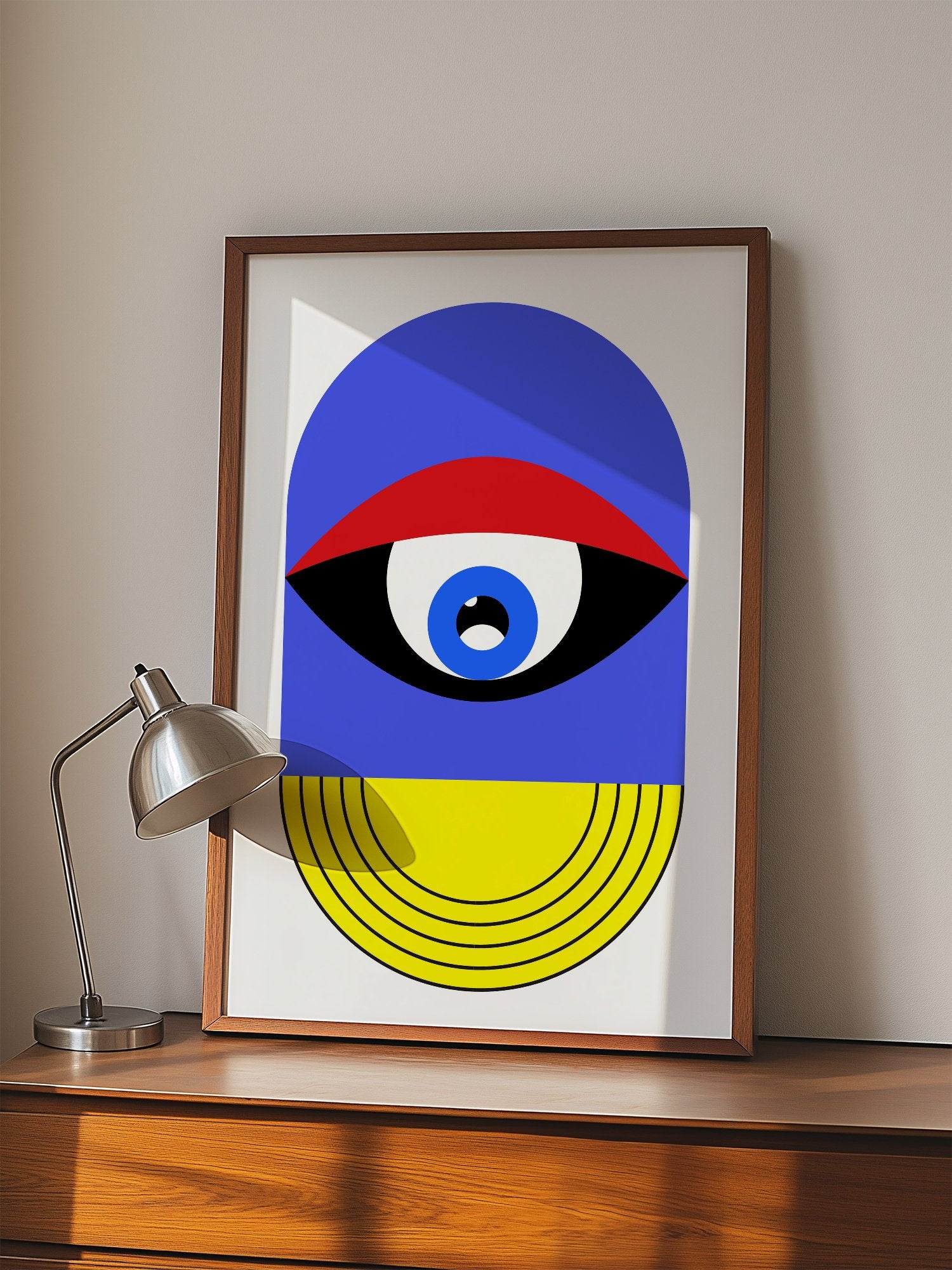 Pop art portrait print featuring geometric eye with concentric circles in blue, displayed in modern living room setting